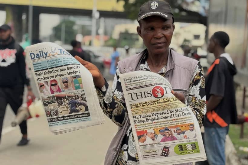 A vendor display local newspapers on the street of Lagos with headlines of the Government Girls Comprehensive Secondary School, where gunmen on Monday attacked the school dormitory, abducted schoolgirls, in Kebbi Nigeria, Wednesday, Nov. 19 2025. (Credit: Sunday Alamba/AP.)