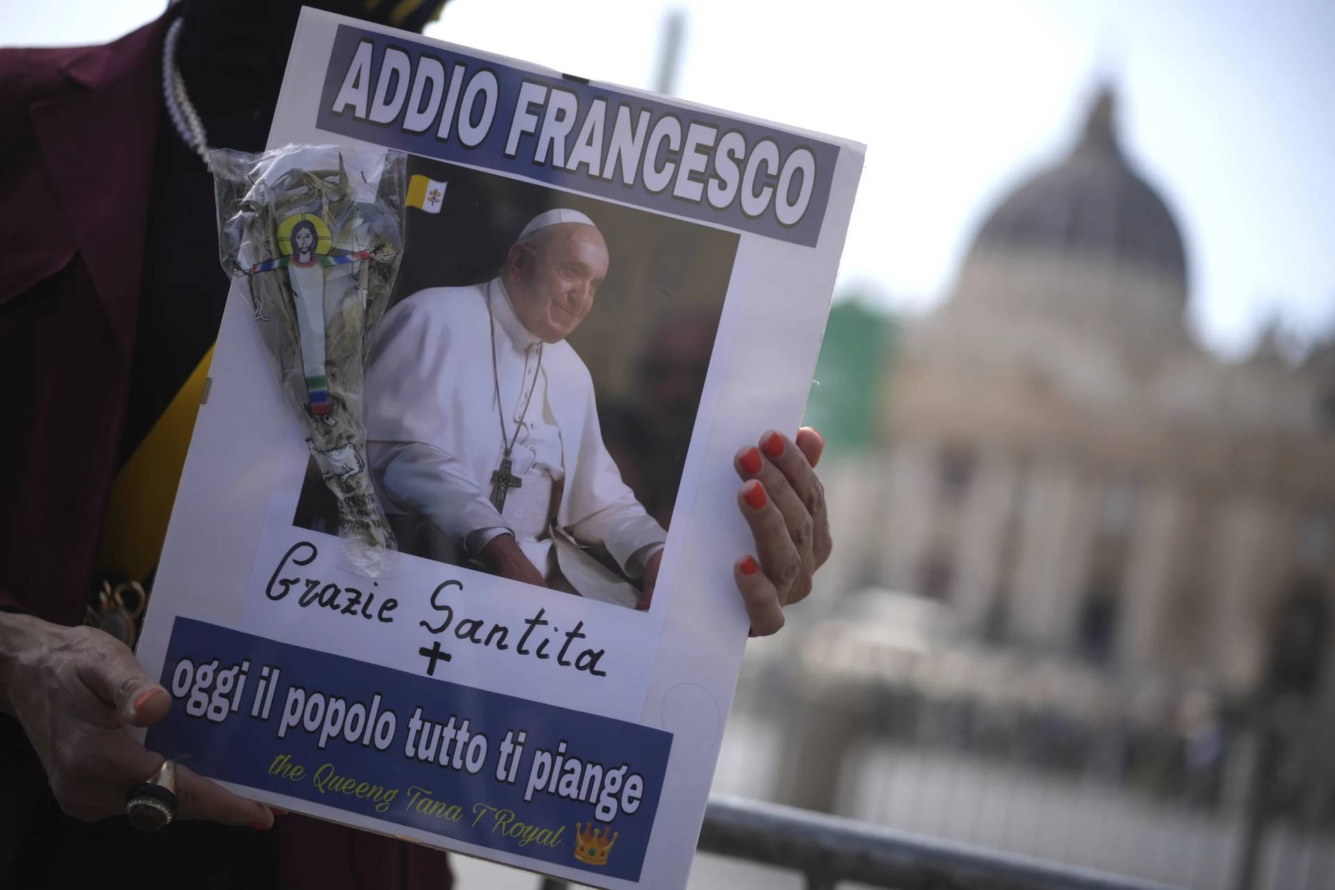 A woman holds a picture of Pope Francis reading in Italian “Farewell Francis, thank you His Holiness, today all the people cry for you” in St. Peter’s Square at the Vatican after Cardinal Camerlengo Kevin Joseph Farrell announced the death of Pope Francis, Monday, April 21, 2025. (Credit: Andrew Medichini/AP.)