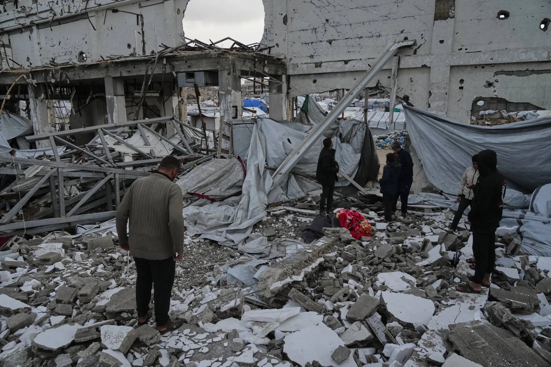 People inspect the site where at least four Palestinians died following the collapse of walls onto tents sheltering displaced people in Gaza City amid rainfall and strong winds, Tuesday, Jan. 13, 2026. (Credit: Jehad Alshrafi/AP.)