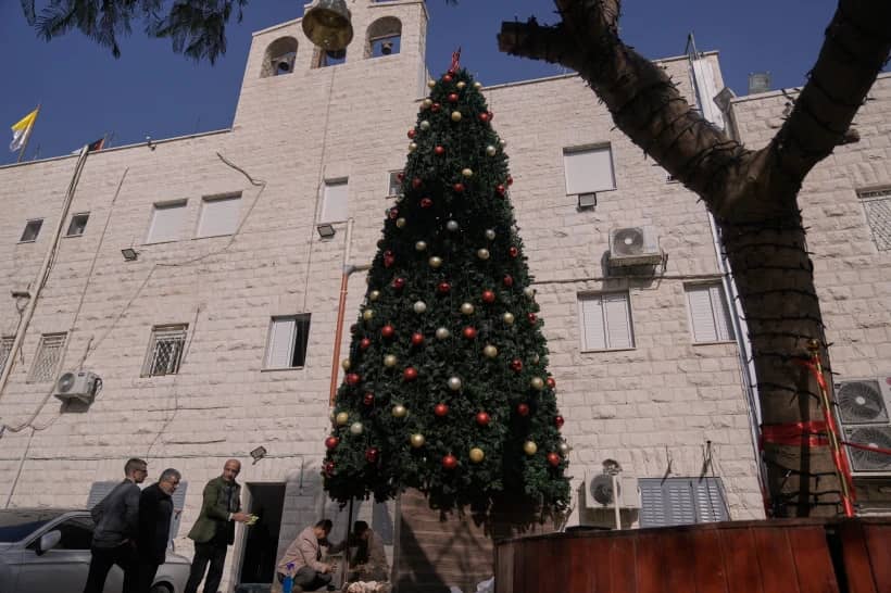 Palestinian parishioners check a recently installed Christmas tree after the previous one was destroyed at the Holy Redeemer Latin Church in the West Bank town of Jenin, Tuesday, Dec. 23, 2025. (Credit: Majdi Mohammed/AP.)