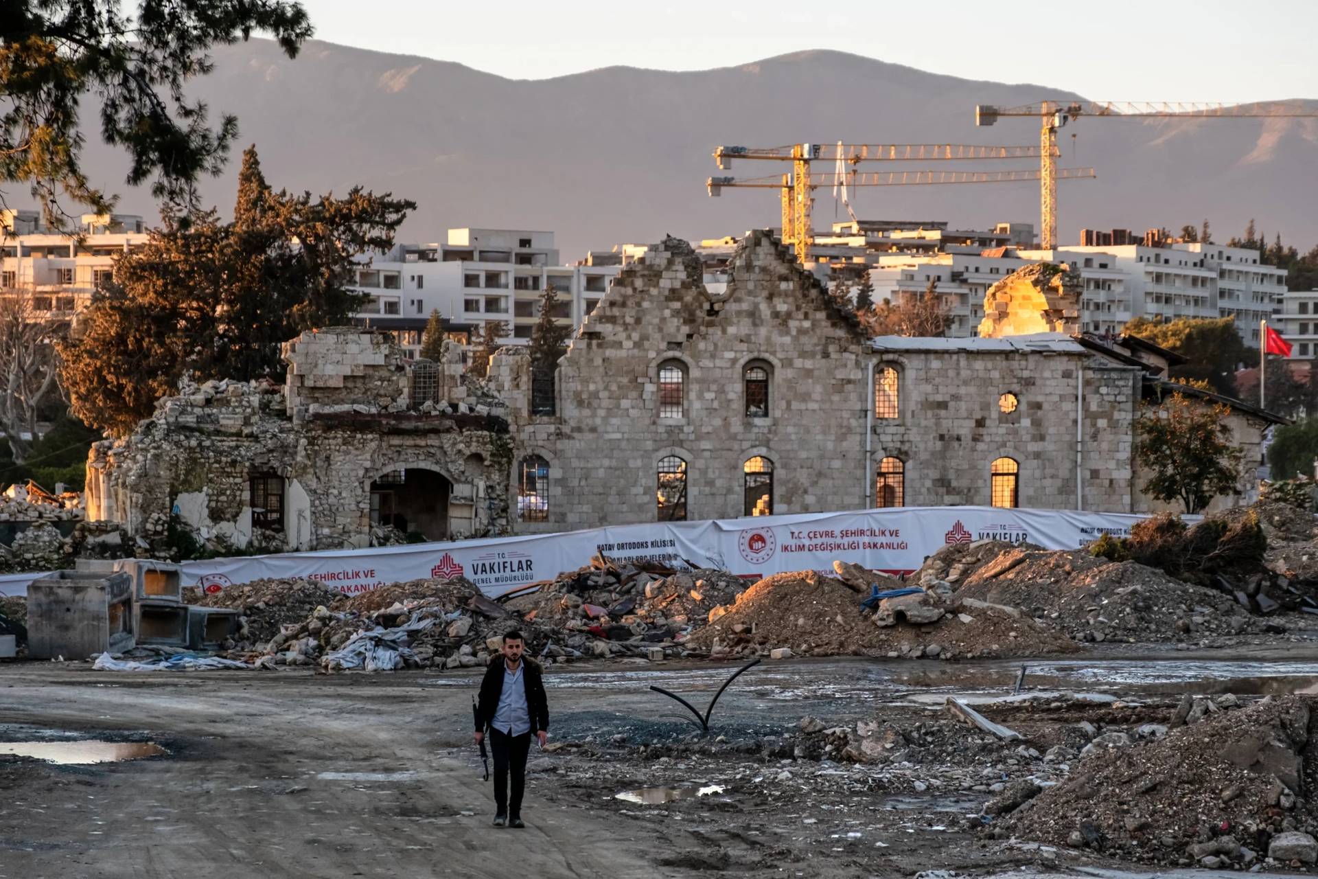 A man walks past the ruins of St. Paul Orthodox Church during debris removal efforts following the February 2023 earthquakes in Antakya, southern Turkey, Wednesday, Feb. 4, 2026. (Credit: Murat Kocabas/AP.)